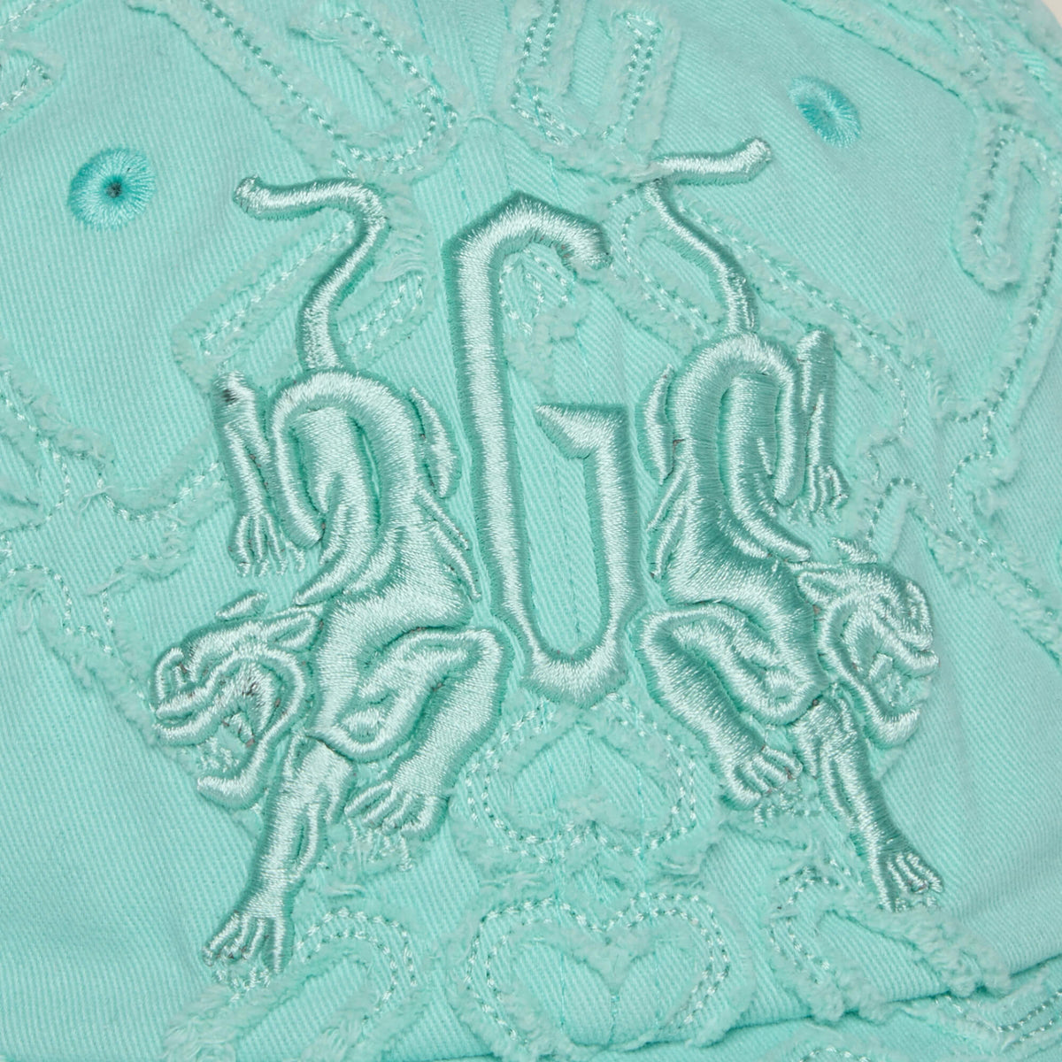 The Goorin Bros. Future Baby Daddy cap features aqua fabric with all-over embroidery, two mirrored lions, and central GU letters—perfect for main character vibes.