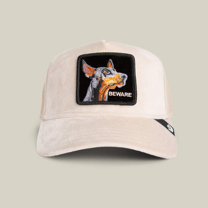 The Goorin Bros. Velour Doberman cap in BISCUIT features a mesh back, a playful Doberman patch, and "BEWARE" on the front—a luxury statement hat blending standout detail with style.