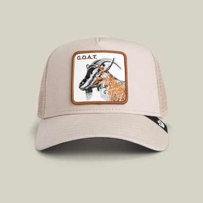 The Goorin Bros. Goat Trucker hat in BISCUIT features neutral tones, a mesh back, and a bold goat head patch with "G.O.A.T." embroidered above.