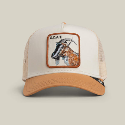 The Goorin Bros. Goat Trucker hat in CHALK / HEAT features a bold goat’s head patch with “G.O.A.T.” embroidered above, crafted in versatile neutral tones.