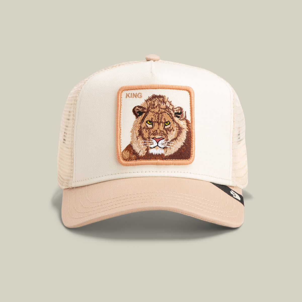 The Goorin Bros. King Trucker hat in Chalk/Blur features a mesh back and a front patch with a lion’s face and “KING” embroidered above it.