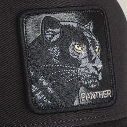 Close-up of the Goorin Bros. Panther Trucker hat with a black patch, featuring an embroidered panther head with yellow eyes and "PANTHER" stitched below.