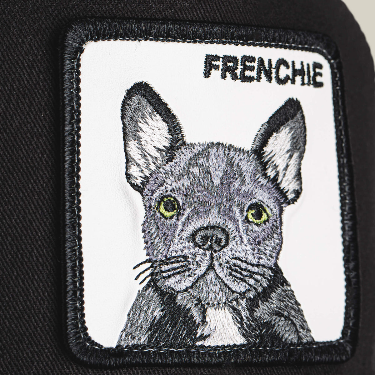 Add a playful touch to your look with the Goorin Bros. *Frenchie Trucker*—featuring an embroidered patch of a French Bulldog’s face and the word FRENCHIE above it, sewn onto classic black fabric—perfect for adding personality to your favorite cap.