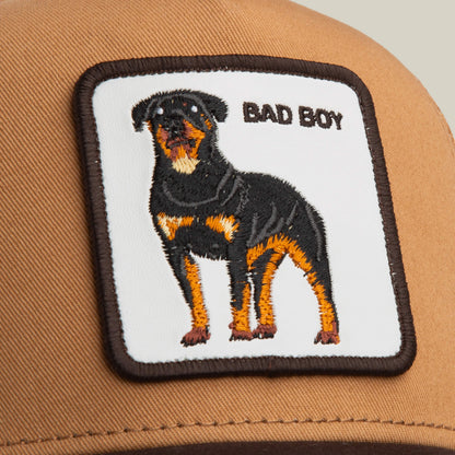 The Bad Boy Trucker by Goorin Bros. is a brown cap with a square patch featuring an embroidered Rottweiler and BAD BOY text—a bold addition to your collection.
