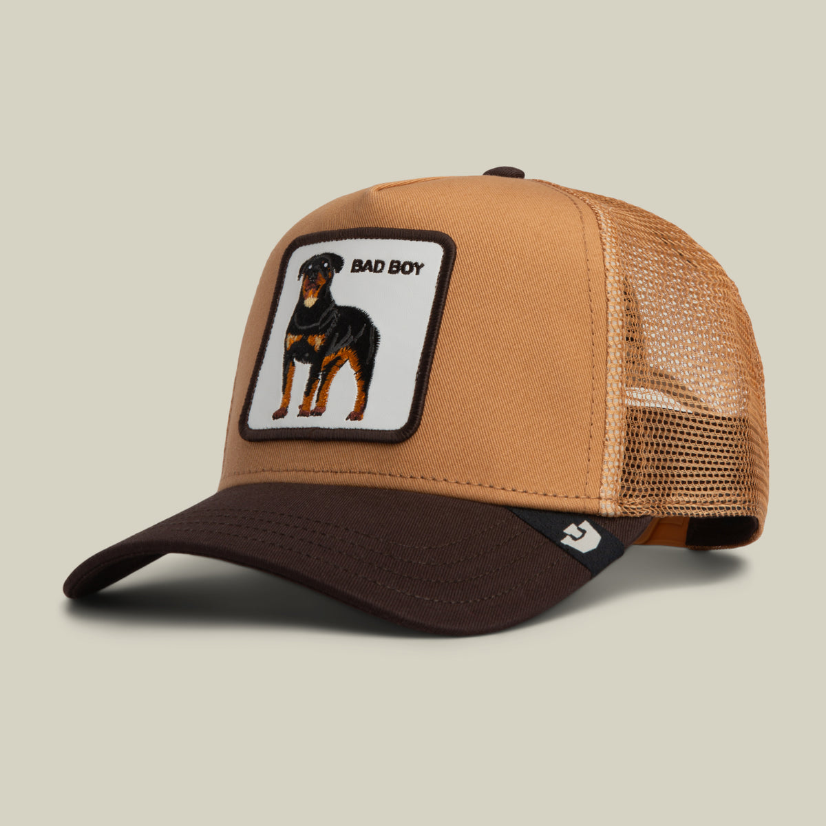 Goorin Bros. Bad Boy Trucker hat in tan and brown, featuring a patch of a Rottweiler and the text BAD BOY.