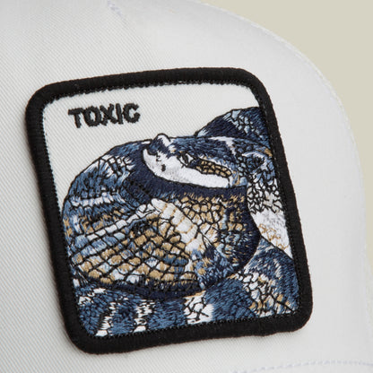 The Goorin Bros. Toxic Trucker features a white patch with an embroidered snake and "TOXIC" in black lettering, sewn onto a white fabric background.