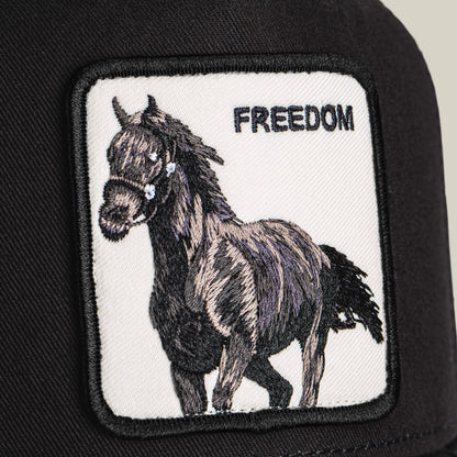 A close-up of the Goorin Bros. Freedom Horse black cap, showcasing a horse trucker patch and bold FREEDOM lettering—an emblem of wild, open-road spirit.