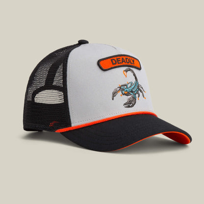 The Goorin Bros. Pop Rocker Scorpion hat features a grey front panel, black mesh back, orange trim, curved brim, and bold scorpion embroidery beneath a "DEADLY" patch.
