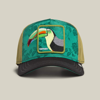 The Goorin Bros. Belize Toucan trucker hat features a green and khaki design with a floral front panel, a Belize Toucan patch, and the word "VISTOSO.