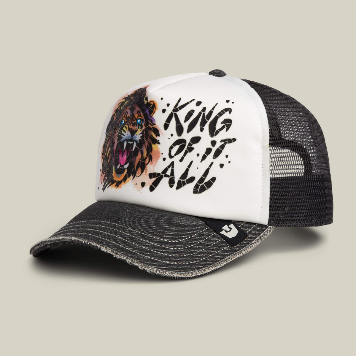 The Goorin Bros. King Disruption trucker hat features a bold black and white design with a roaring lion graphic and KING OF IT ALL text on the front panel.