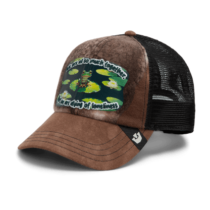 The Goorin Bros. Lil Sohei is a brown and black trucker hat from our Storybook collection, featuring a frog on lily pads and the phrase "It's a cold old swamp tonight, I'm the frog of loneliness.