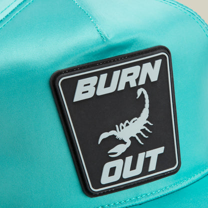 Close-up of the Goorin Bros. Pole Position - Road Kill racing cap in teal, featuring sleek chrome satin stripes and a black and white patch displaying the words BURN OUT with a scorpion image.