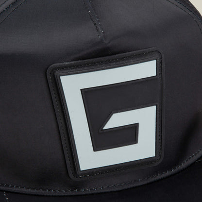 Close-up of the Goorin Bros. Pole Position - Road Kill racing cap in black fabric, featuring a prominent square patch with a stylized black and white G logo on the front and subtle chrome satin stripes for a sleek, modern finish.
