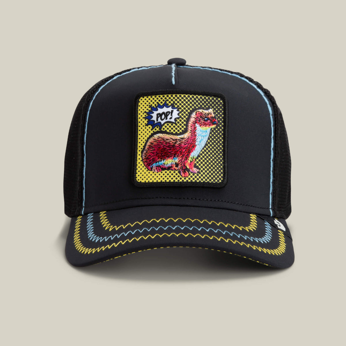 The Goorin Bros. "All Around the Mulberry Bush" trucker hat in VOID features bold colors, a playful cartoon animal patch with "POP!" up front, and yellow-blue zigzag stitching on the brim for a pop art twist.