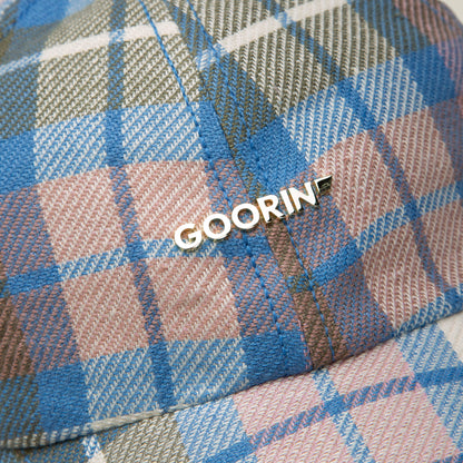 Close-up of a plaid Bespoke Wordmark V2 cap by Goorin Bros. in blue, pink, and green, featuring a metallic GOORIN pin on the side and showcasing this papa cap’s distinctive style.