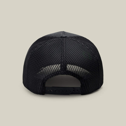 NeoBrand GOAT by Goorin Bros.—black mesh-back trucker hat shown from the rear with adjustable snapback closure and subtle branding, set against a beige background. Ideal to match with your favorite monochrome sneakers.
