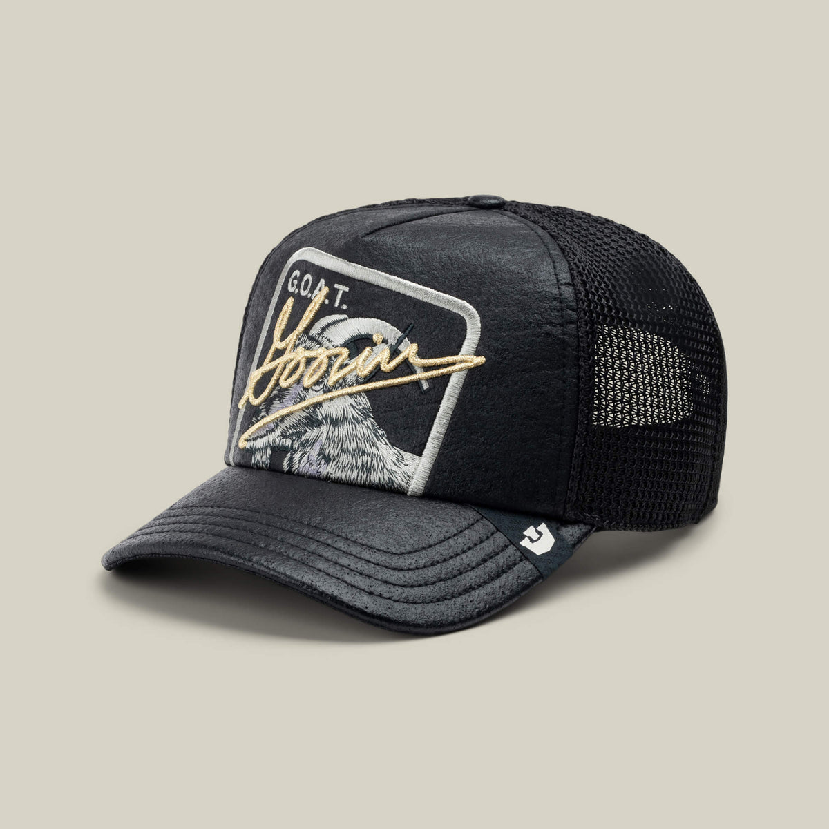 The Goorin Bros. NeoBrand GOAT is a black mesh trucker hat with a curved brim and an eagle patch reading "G.O.A.T. Born"—ideal for pairing with monochrome sneakers for a bold, laid-back style.