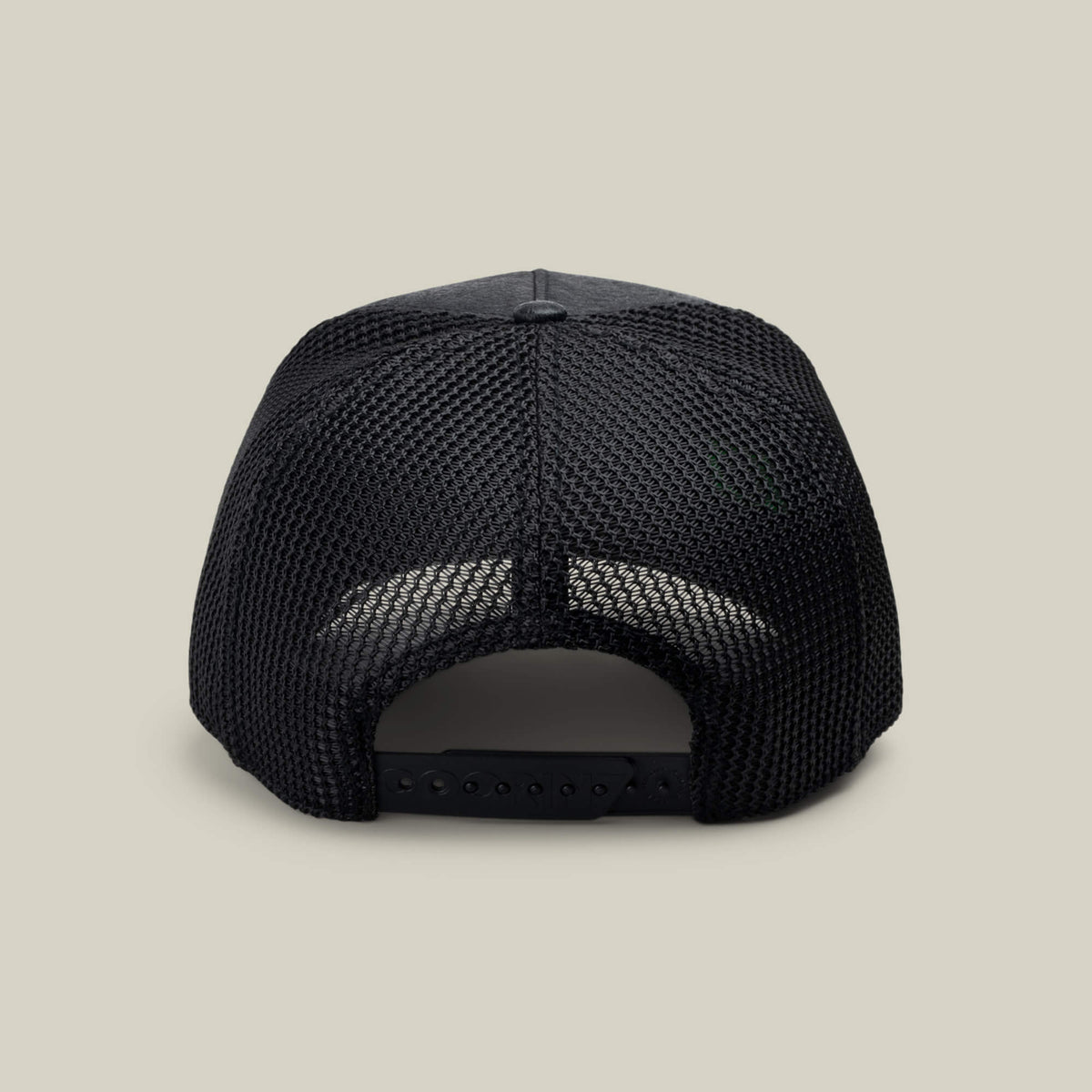 The NeoBrand STALLION trucker hat by Goorin Bros. is shown from the rear, displaying its black mesh back, matching snapback closure, and monochrome embroidery on a simple light beige background.