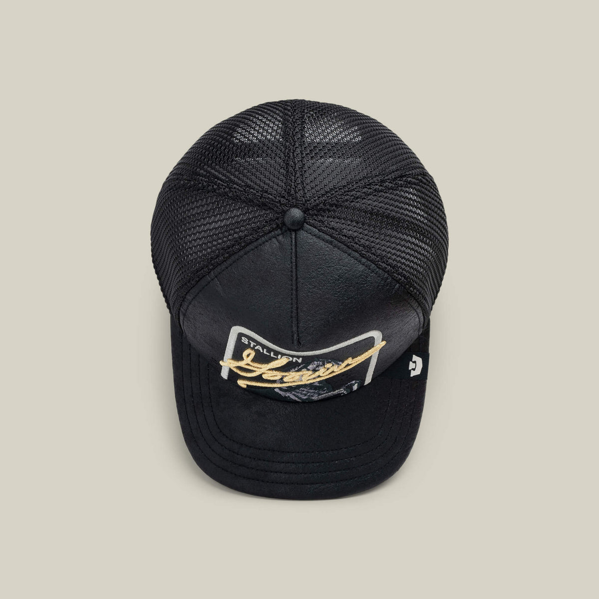 The NeoBrand STALLION by Goorin Bros. is a black mesh trucker hat with a curved bill, gold monochrome "STALLION Jeans" patch on the front—ideal for pairing with blacked-out sneakers.