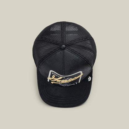 The NeoBrand STALLION by Goorin Bros. is a black mesh trucker hat with a curved bill, gold monochrome "STALLION Jeans" patch on the front—ideal for pairing with blacked-out sneakers.
