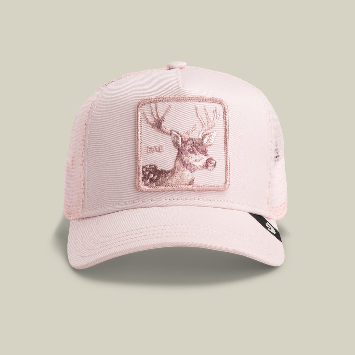 The Mirage Bae by Goorin Bros. is a WHISPER-colored mesh trucker hat featuring a stitched deer patch with antlers and the word “BAE” on the front panel, a curved brim, and a black side tag.