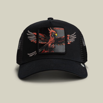 The Wings Forever trucker hat by Goorin Bros features a black mesh back and solid front panel with a large embroidered red and orange phoenix design and gray wing details, displayed on a neutral background.