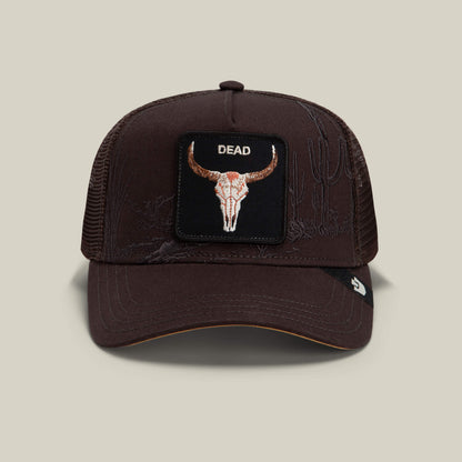 A "Ground" colored mesh trucker hat from Goorin Bros. called the Badlands Skull, featuring a front patch with a bull skull and the word DEAD, with subtle embroidered cactus illustrations on the cap.