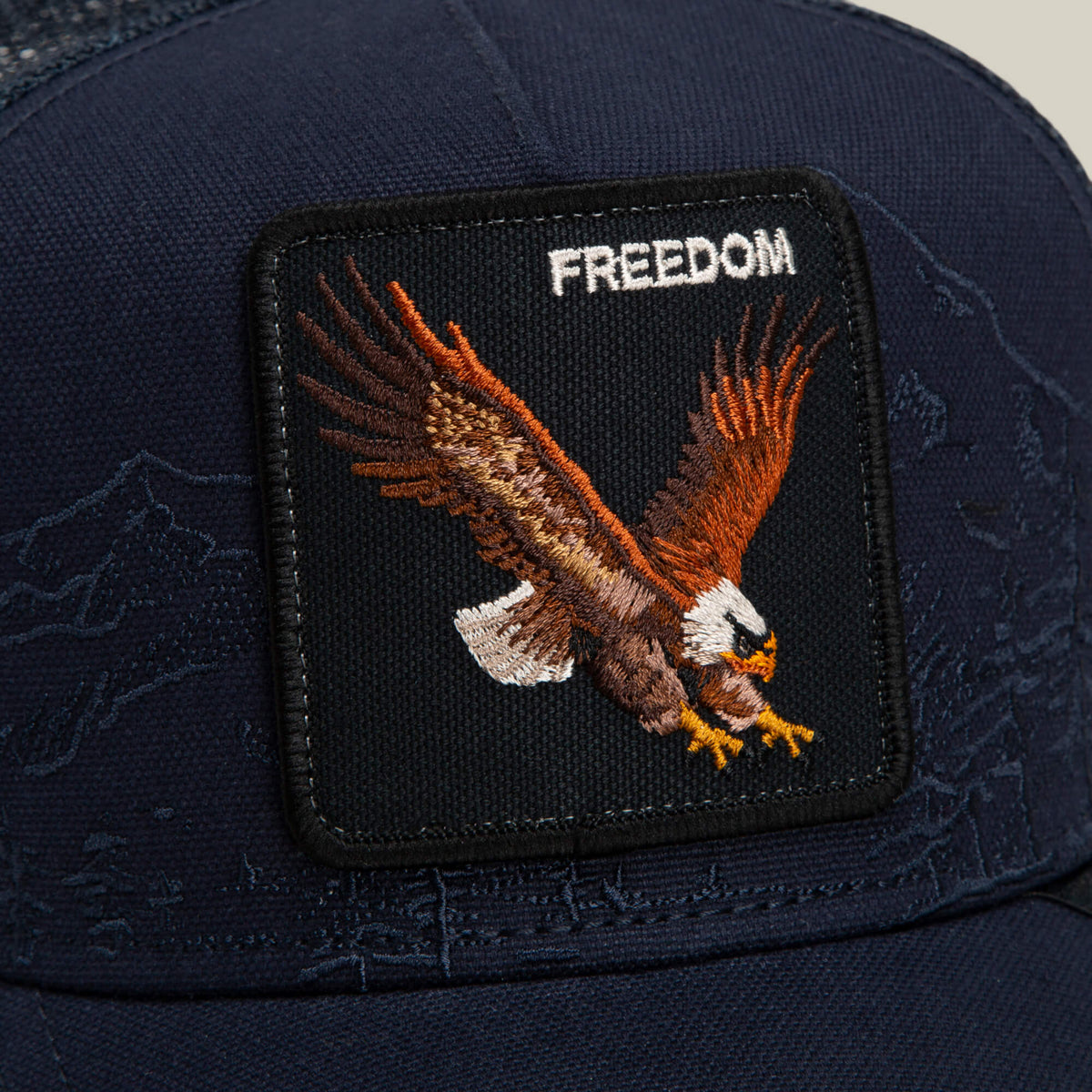 A navy Goorin Bros. Badlands Eagle cap featuring a patch with an embroidered flying eagle and the word "FREEDOM" stitched above it.