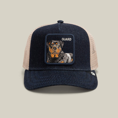 Introducing the Goorin Bros. Denim Guard—a dark denim snapback trucker hat featuring a square embroidered Rottweiler patch with the word "GUARD" on a light tan mesh background.