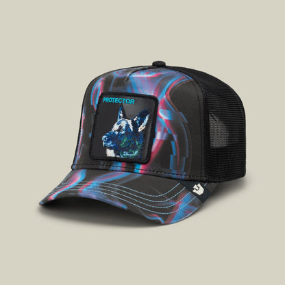 The Goorin Bros. Baba Yaga trucker hat features a holographic blue and pink swirl pattern on the front panels with a black mesh back, a wolf patch embroidered on the front, and "PROTECTOR" text, displayed against a neutral beige background.