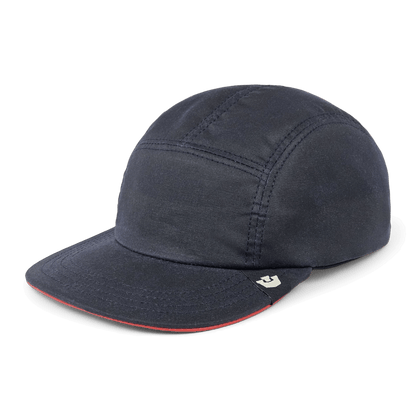 The North Boulder by Goorin Bros. is a dark navy 5-panel camp cap with visible stitching, flat brim, and a small beige logo tag on the front left side, hand cut and sewn in the USA.