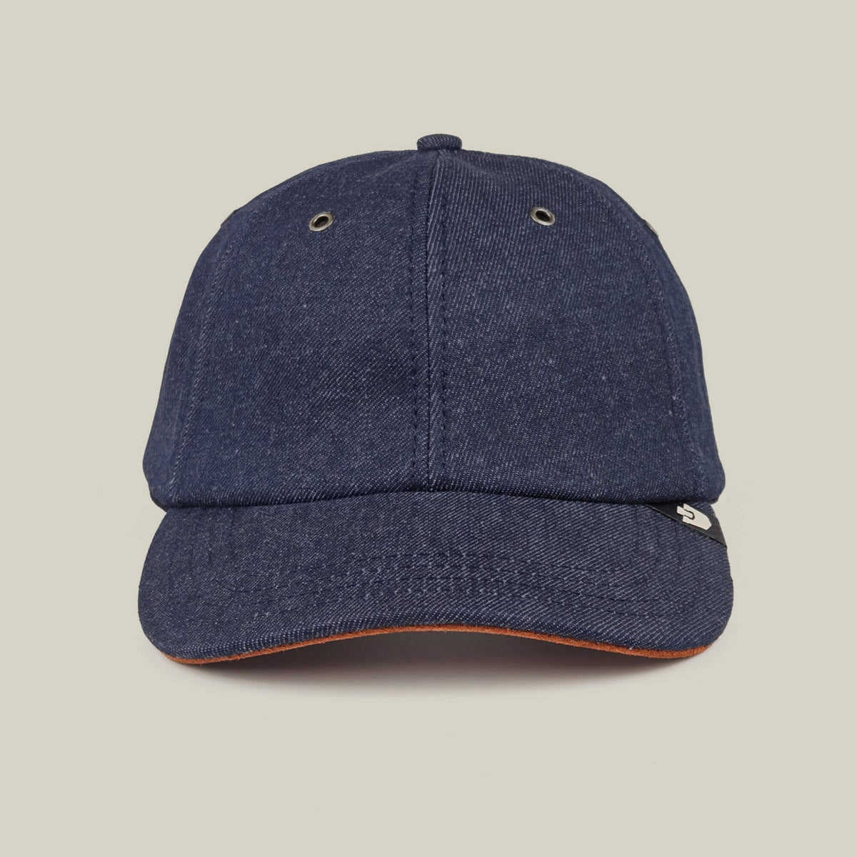 The Legend Ridge by Goorin Bros. is a dark denim baseball cap, made in the USA, with metal eyelets and a small black and white side tag, shown on a plain beige background.