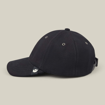 The Mineral Road baseball cap by Goorin Bros. is shown side-on against a plain light background. This black, mixed-material cap features metal eyelets, an adjustable strap, and is made in the USA.