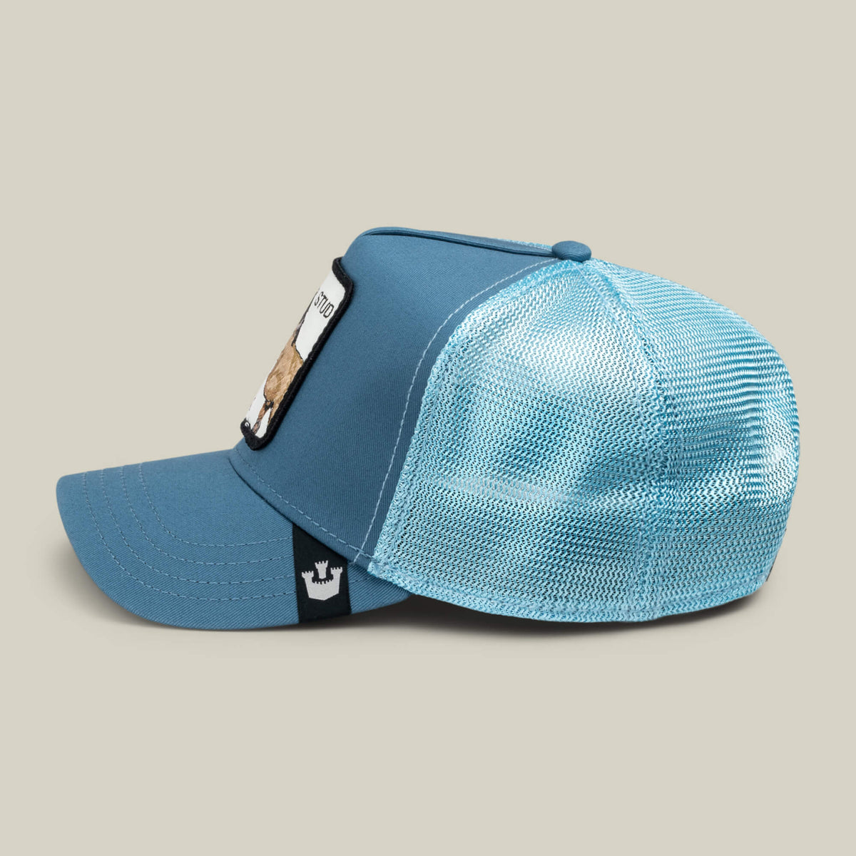 The "Dad and Pony Show (Adult)" by Goorin Bros. is a blue trucker hat with a mesh back, solid front, and rectangular patch, shown in profile against a neutral background.