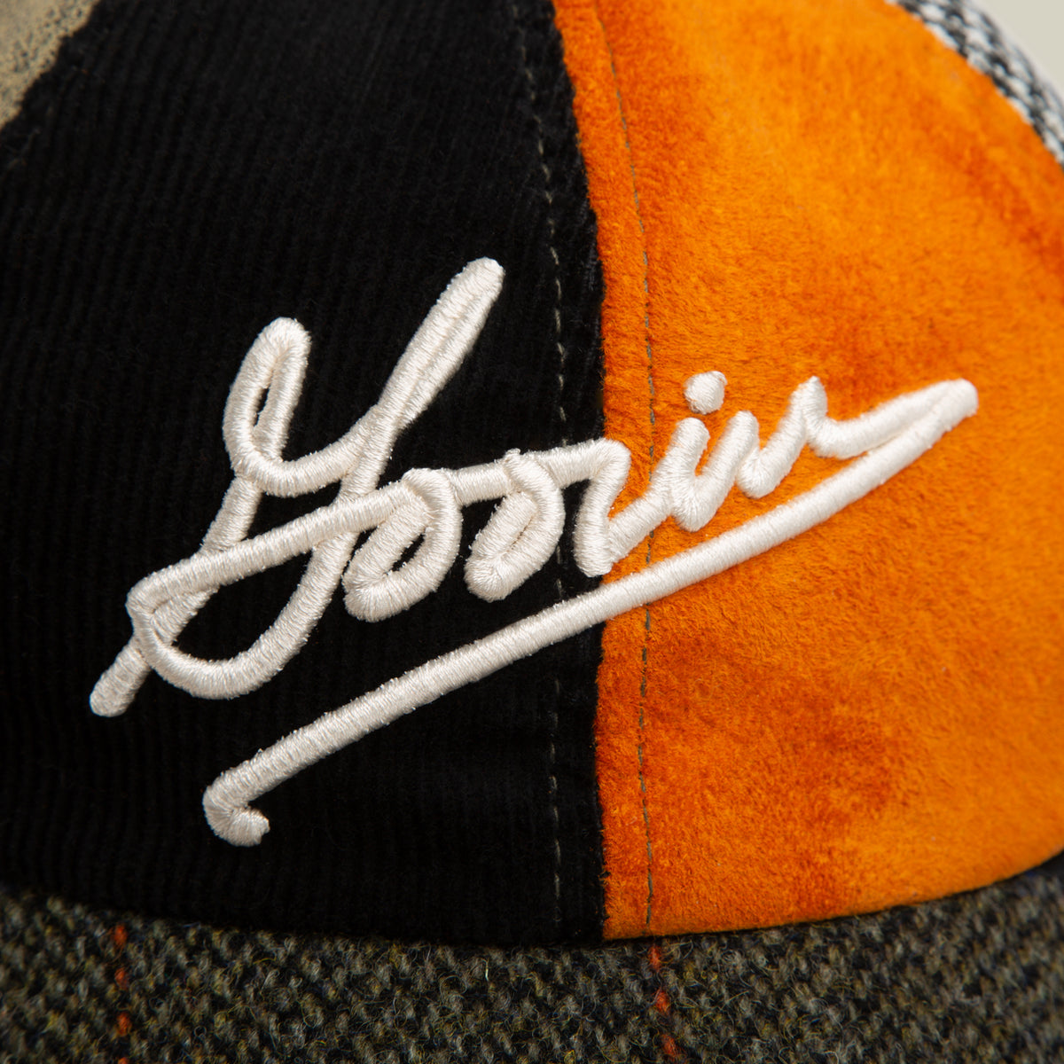 A close-up of the "South Bay" Papa hat by Goorin Bros., featuring textured panels in black, orange, and gray with "Yorin" embroidered in white Goorin Script on the front.