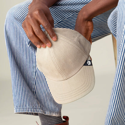 A person holds the Goorin Bros. Noisy Tailored Baseball cap, showcasing color-driven style and subtle confidence with a small black and white logo tag on the side.