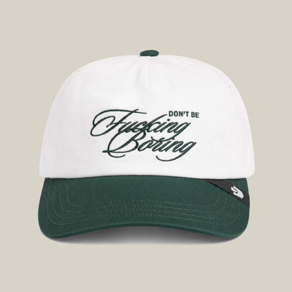A Goorin Bros. "Don't Be Fucking Boring" cap in Dust/Palm with the slogan embroidered in cursive on the front.