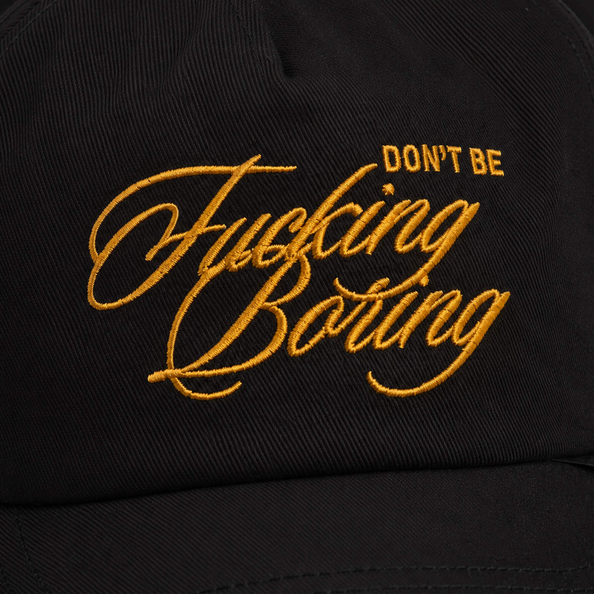 The Goorin Bros. "Don't Be Fucking Boring" cap is a black baseball hat with bold gold embroidered text.