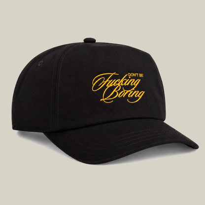 Black two-tone cap by Goorin Bros. featuring yellow “Don't Be Fucking Boring” cursive text on the front, displayed against a plain light background.
