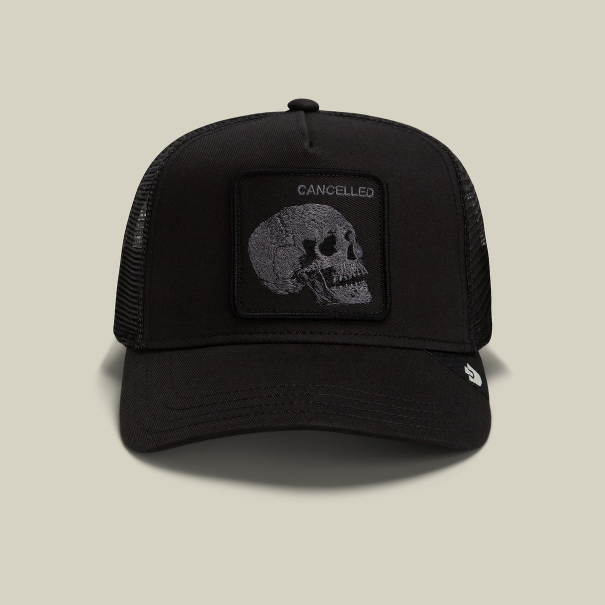 The Goorin Bros. Tonal Skull trucker hat features a black mesh back with a solid black front panel displaying a gray skull patch embossed with "Cancelled" text, shown against a neutral background.