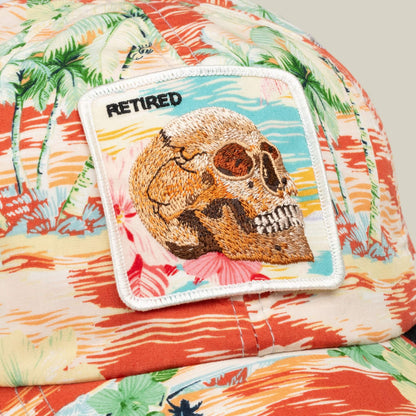 The Funemployed Forever papa cap by Goorin Bros. features a vibrant floral print, a skull patch with "RETIRED" embroidery, and is set against a sunset and palm tree background—perfect for celebrating the funemployed life.