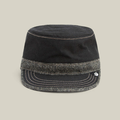 The Goorin Bros. Ampere cap in VOID features a flat top, short brim, and a grey tweed band at the base, shown against a plain beige background.