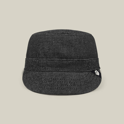 The Goorin Bros. Devonshire cap in black denim features a short brim and folded band, hand cut and sewn, displayed against a plain beige background.