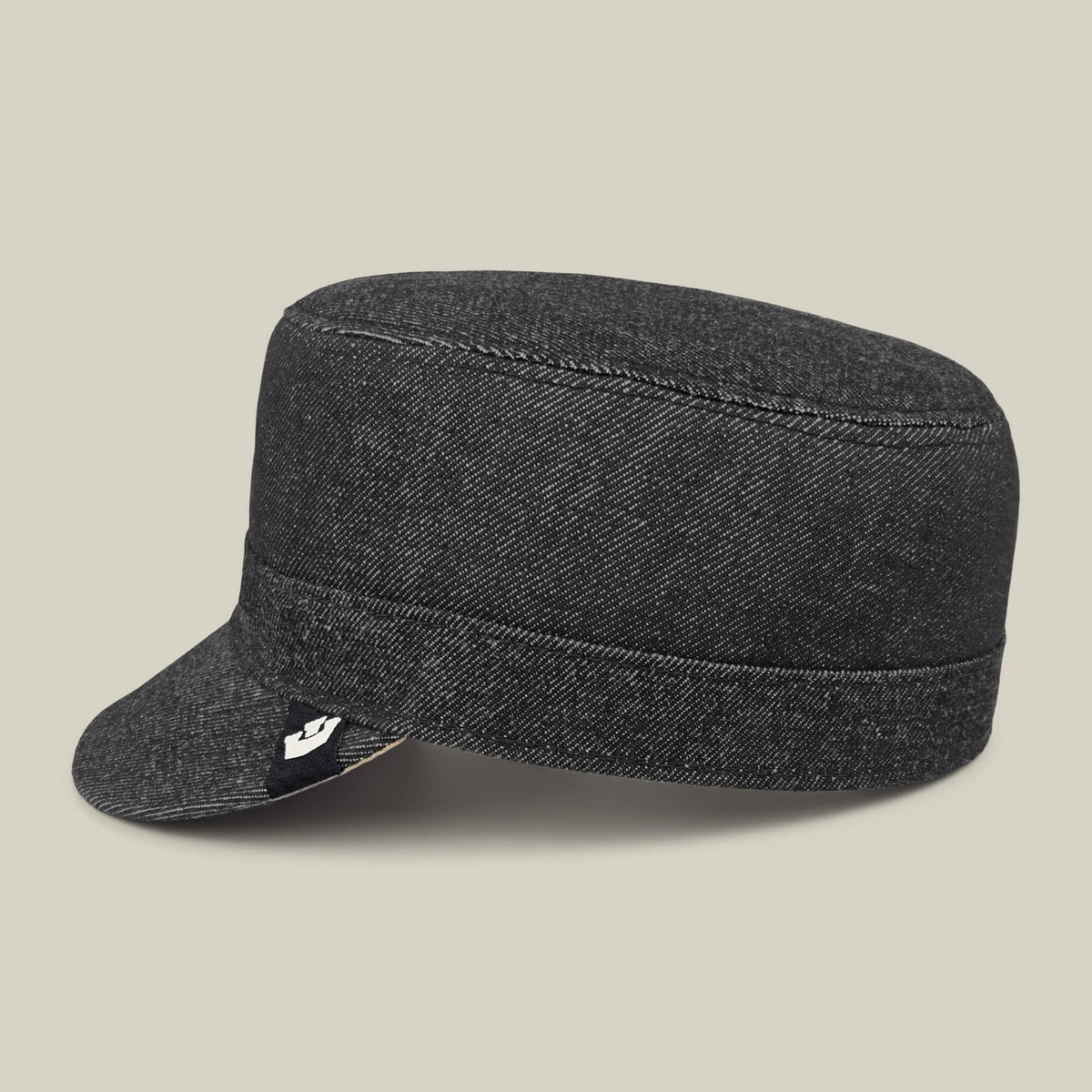 The Goorin Bros. Devonshire is a dark gray, hand-sewn cotton military-style cadet cap with a short brim and small black tag, made in the USA, shown on a plain beige background.
