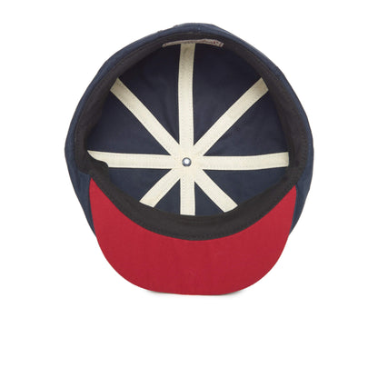 Certainly! Here’s a rewritten sentence using your product data: The Goorin Bros. Mulberry Street baseball cap features a stylish flatcap design, revealing a navy blue interior with white seam strips and a bold red brim—blending classic sporty appeal with modern flair.