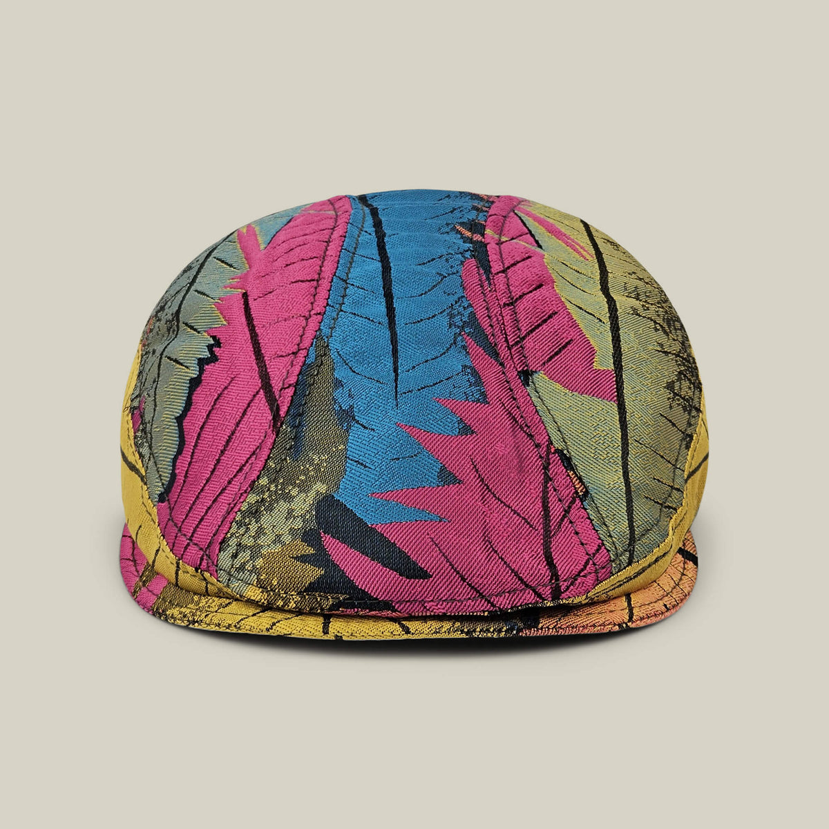 The Goorin Bros. Upland Avenue flatcap features a vibrant, multi-color abstract feather print and is hand cut and sewn for a unique look. Shown against a plain beige background.