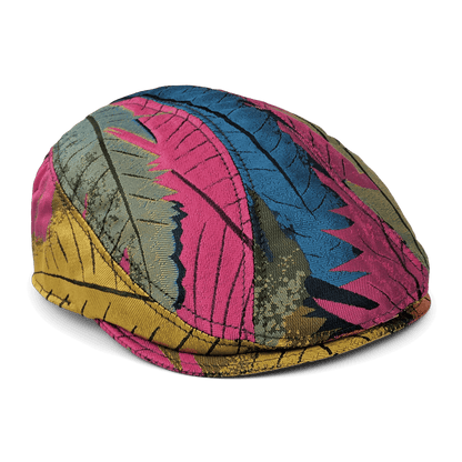 The Upland Avenue flatcap by Goorin Bros. is hand sewn in the USA and showcases a tropical print with multicolored pink, blue, yellow, and green feathers on a white background.