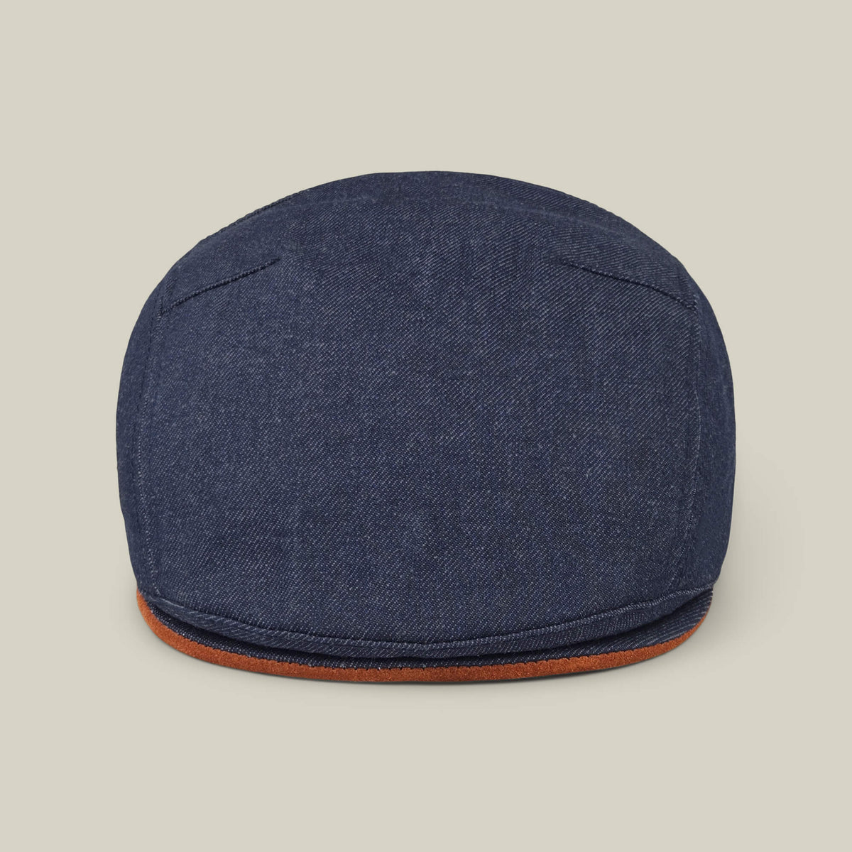 The Goorin Bros. Ashfield flat cap in dark denim cotton suede features visible stitching and a brown trim, made in the USA and shown against a plain beige background.