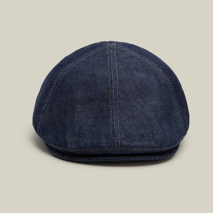 The Goorin Bros. Noisy Benjamin Paul flatcap in indigo is displayed from the front against a light background, highlighting its versatility as a neutral accessory for any outfit.