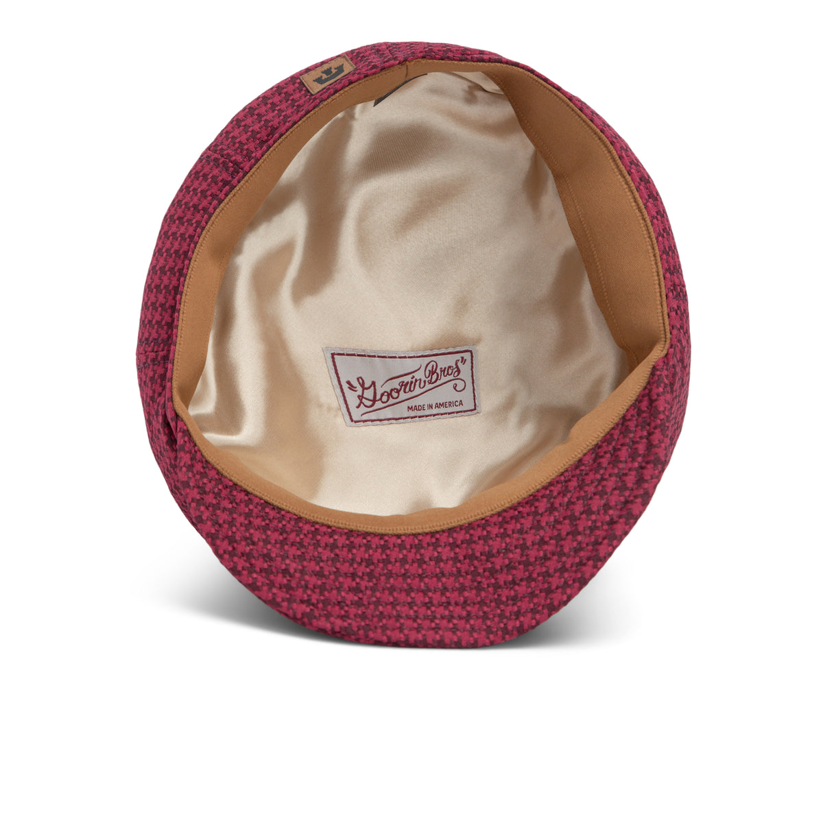 A red houndstooth-patterned Goorin Bros. Cold Snap cabbie flatcap with a tan satin lining, viewed from above to display the Made in America label and German wicking sweatband inside.